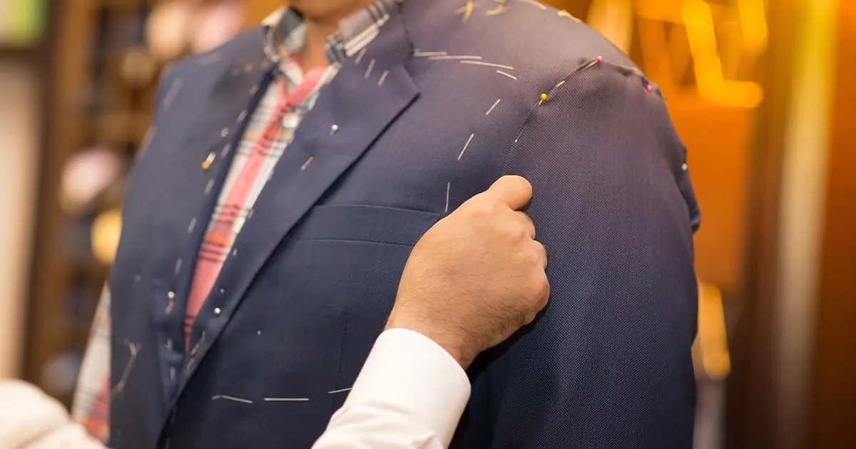 Tailor working with custom made suit