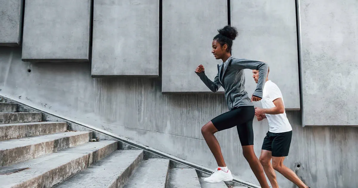 Athletic man and woman going up stairs